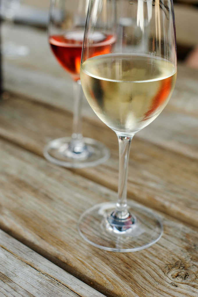 Weinglas mit Rotwein und Weisswein auf dem Tisch | Großklein, Austria - August 25, 2012: Buschenschank Wölfl; Weinglas mit Rotwein und Weisswein auf dem Tisch. - Realisiert mit Pictrs.com