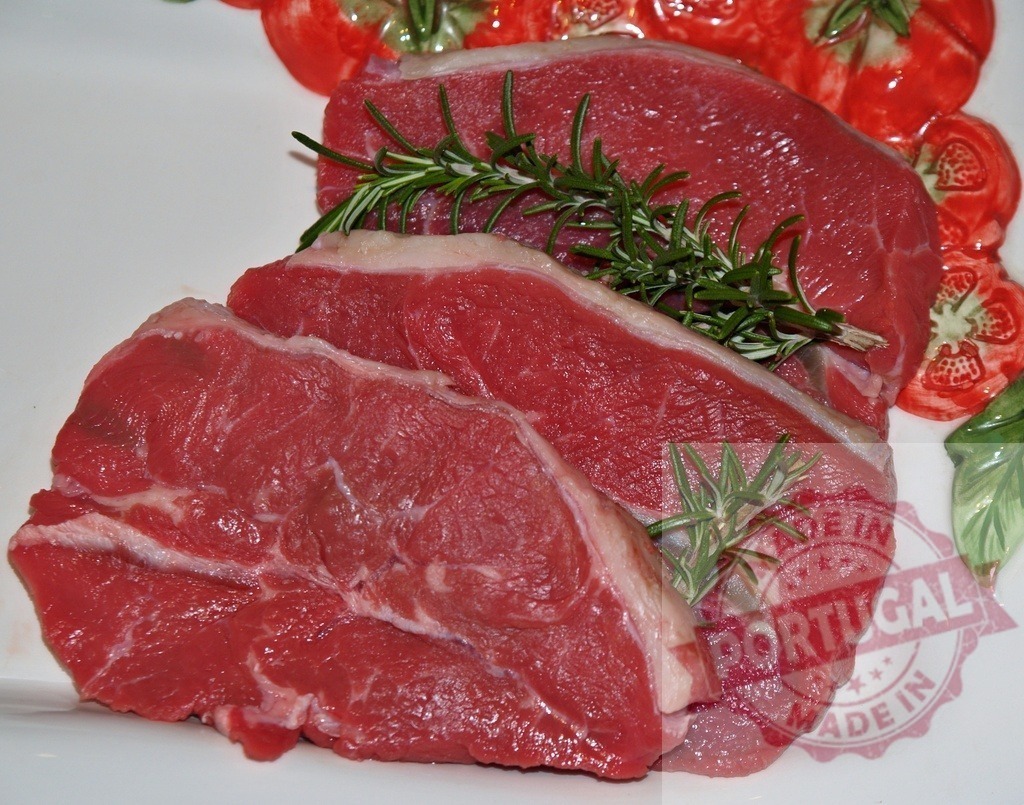 Raw beef steaks with fresh rosemary on plate | Raw beef steaks with rosemary sprigs preparing for cooking - Realized with Pictrs.com