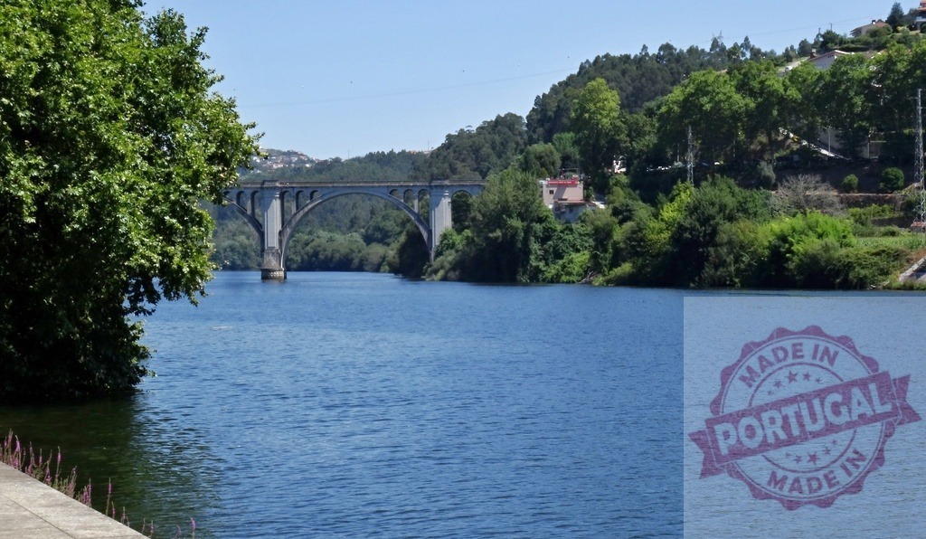 Douro River landscape with Tâmega bridge in Amarante, Portugal | Douro River flowing past the Tâmega bridge connecting green hillsides in Amarante - Realized with Pictrs.com