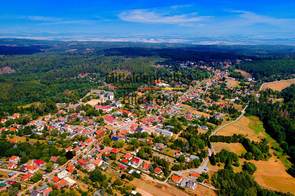 Friedrichsbrunn-Harz-Luftbild-von-oben_0038 | Die Luftaufnahme zeigt Friedrichsbrunn mit seiner gewachsenen Ortsstruktur inmitten der Harzlandschaft. Wohnhäuser, Wiesen und ausgedehnte Waldflächen bestimmen das Bild. Aus der Vogelperspektive wird die ruhige und naturnahe Lage des Erholungsortes im Harz besonders deutlich. - Realisiert mit Pictrs.com