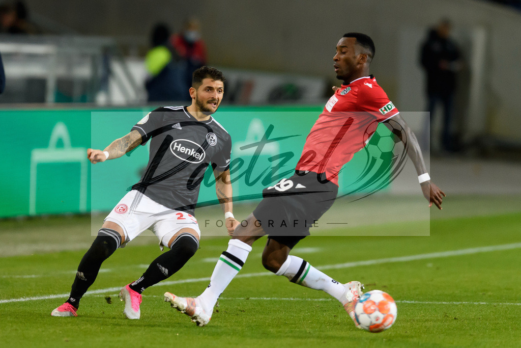 H96DUS20211027_042 | Fussball, Herren: Matthias Zimmermann (Fortuna Duesseldorf) und Gael Ondoua (Hannover 96) im Zweikampf bei dem Spiel der 2. Runde im DFB-Pokal zwischen Hannover 96 und Fortuna Duesseldorf in der HDI-Arena am 27.10.2021 in Hannover, Deutschland.DFB / DFL REGULATIONS PROHIBIT ANY USE OF PHOTOGRAPHS AS IMAGE SEQUENCES AND/OR QUASI-VIDEO. - Realisiert mit Pictrs.com