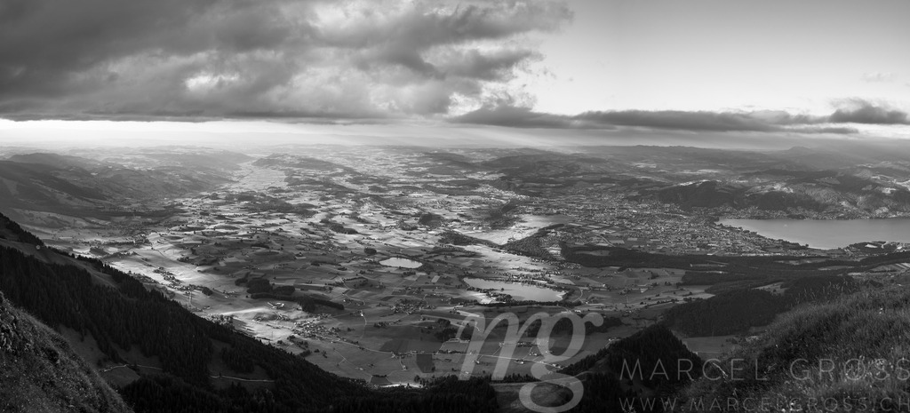 Simmental Valley Panorama at Dawn, Switzerland | A sweeping panoramic view showcases the Simmental valley bathed in the soft light of dawn. Rolling green hills and scattered villages are visible, framed by the distant peaks of the Bernese Alps. The scene evokes a sense of tranquility and the beauty of the Swiss countryside. - Realisiert mit Pictrs.com