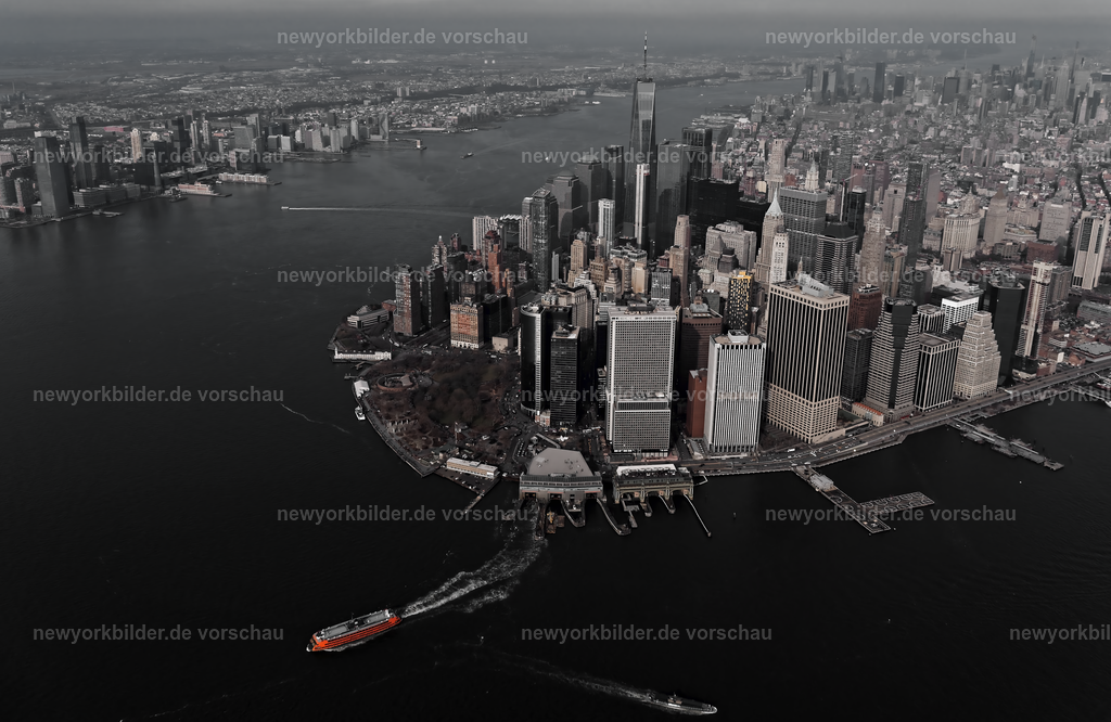 Kontraste auf dem Wasser – Skyline von Manhattan und die rote Staten Island Ferry | Die Skyline von Manhattan aus der Luft – ein Panorama, das die Kraft und Schönheit der Metropole zeigt. Im Vordergrund setzt die rote Staten Island Ferry einen markanten Kontrast zur urbanen Kulisse aus Wolkenkratzern und Brücken. Diese Perspektive vereint Bewegung und Architektur, Wasser und Stadt in einer Komposition, die Dynamik und Ruhe zugleich ausstrahlt. Die Fähre, ein ikonisches Symbol des Alltags in New York, wirkt wie ein roter Akzent vor der majestätischen Skyline, die sich bis zum Horizont erstreckt.
