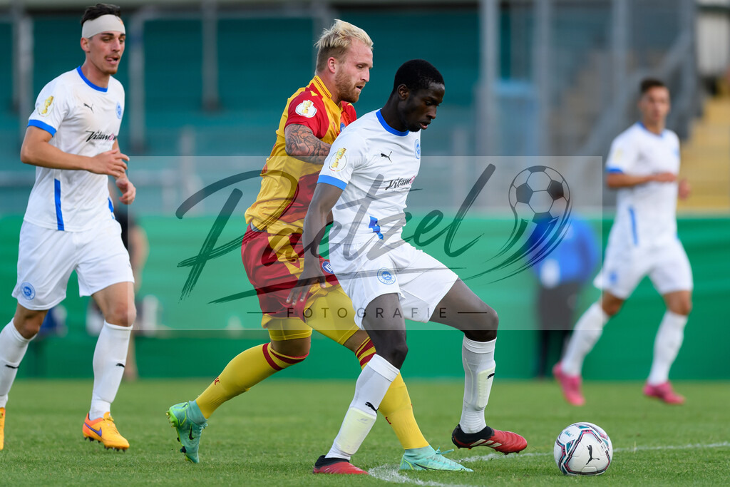 LOTKSC20210809_038 | Fussball, Herren: Philipp Hofmann (Karlsruher SC) und Komlan Fionouke (Sportfreunde Lotte) im Zweikampf beim Spiel der 1. Runde im DFB-Pokal zwischen SF Lotte und Karlsruher SC im Stadion am Lotter Kreuz am 09.08.2021 in Lotte, Deutschland.DFB / DFL REGULATIONS PROHIBIT ANY USE OF PHOTOGRAPHS AS IMAGE SEQUENCES AND/OR QUASI-VIDEO. - Realisiert mit Pictrs.com