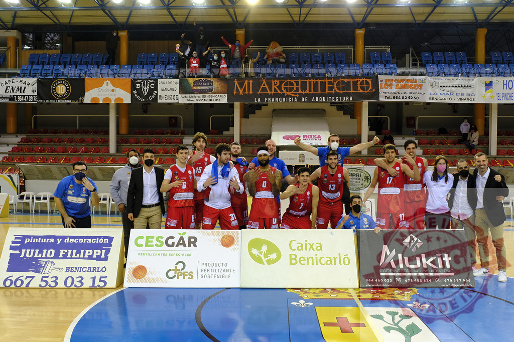 Basketball team players and coaches celebrating victory on court | Basketball team and coaching staff posing for a group celebrating victory on the indoor arena court - Realized with Pictrs.com