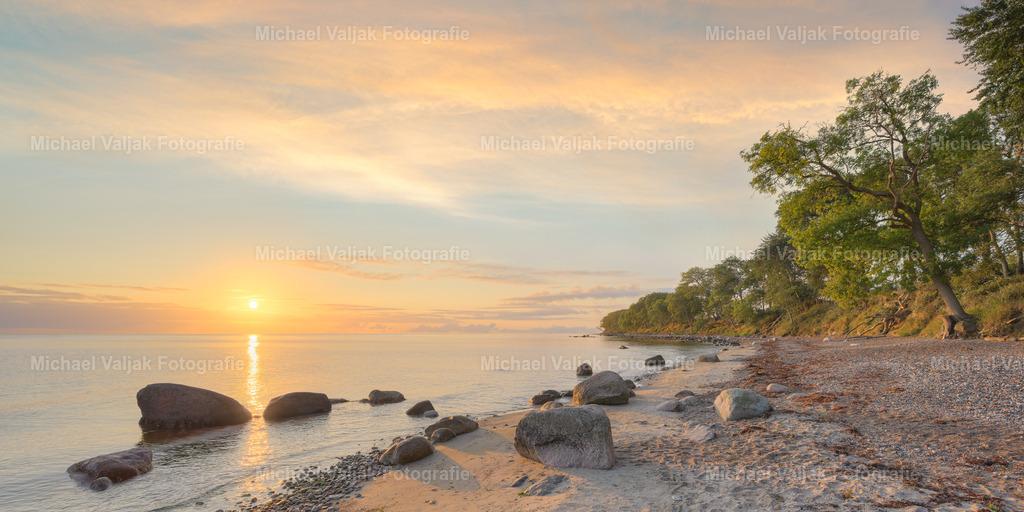 Steilküste Katharinenhof auf Fehmarn bei Sonnenaufgang | Wenn Sie die wilde und natürliche Schönheit der Ostsee erleben wollen, sollten Sie einen Ausflug zur Steilküste Katharinenhof machen. Dieser Küstenabschnitt ist geprägt von abgerutschten Bäumen und Felsbrocken, die dem Strand einen romantischen Charakter verleihen. Von hier aus haben Sie einen herrlichen Blick auf das Meer und können bei gutem Wetter einen spektakulären Sonnenaufgang beobachten. Die Steilküste ist Teil eines Naturschutzgebietes, das viele seltene Pflanzen und Tiere beherbergt. Sie können entlang der Küste wandern oder Rad fahren und die frische Seeluft genießen. - Realisiert mit Pictrs.com