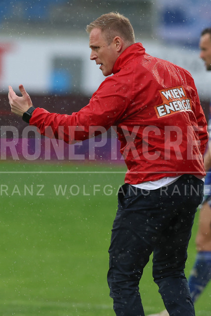TSV Egger Glas Hartberg vs SK Rapid Wien – Championship Group    | Hartberg, Austria, 19.Apr.26 - SOCCER - ADMIRAL Bundesliga, TSV Egger Glas Hartberg vs SK Rapid Wien. The image shows head coach Johannes Hoffthorup (SK Rapid Wien) in rain. 