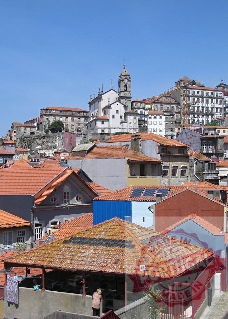 Porto cityscape with old town buildings and church tower | Orange tile rooftops covering traditional dwellings with a historic church on a hill - Realisiert mit Pictrs.com