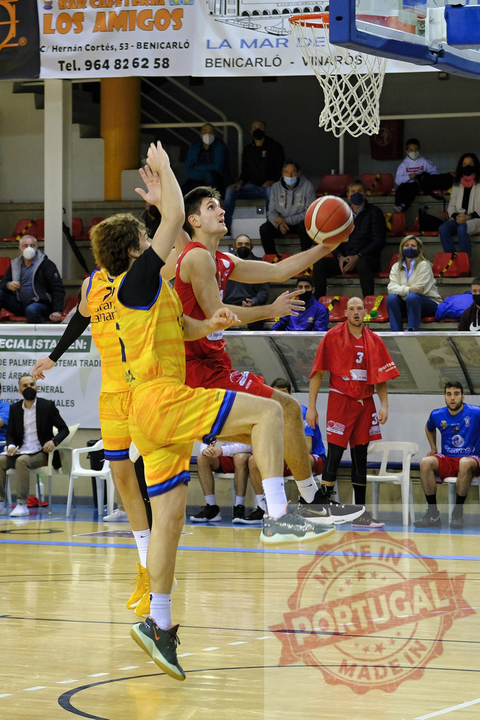 Basketball players competing during an intense game | Two basketball players jumping for a shot, competing for the ball on the court - Realized with Pictrs.com