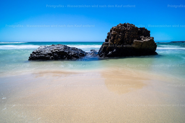 Türkisblaues Meer auf Fuerteventura | Heller Sandstrand auf Fuerteventura mit türkisblauem Wasser, dunklen Felsen und klarem Himmel. Die reduzierte Küstenszene vermittelt Ruhe, Weite und das leichte Gefühl eines sonnigen Tages am Atlantik. - Realisiert mit Pictrs.com