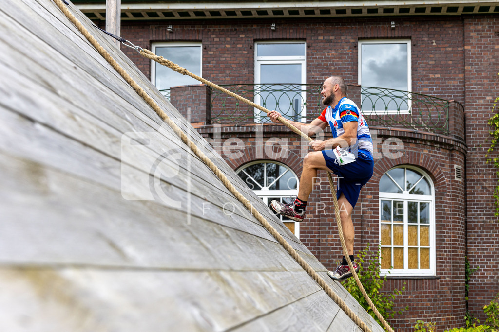 Silas Martin nimmt das Seil und stemmt sich nach oben. Im Hintergrund die ehemlalige Veerßer Klinik zu sehen. | immodelaporte-sportfotos - Realisiert mit Pictrs.com
