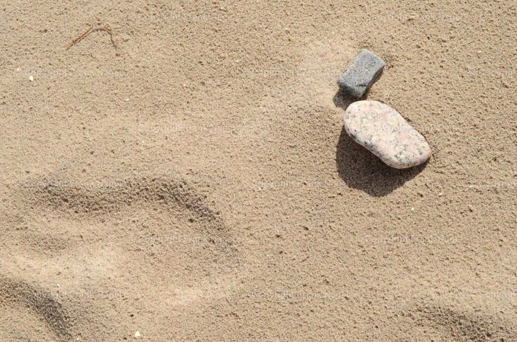 Strandsand mit zwei Steinen | dataxp - Realisiert mit Pictrs.com