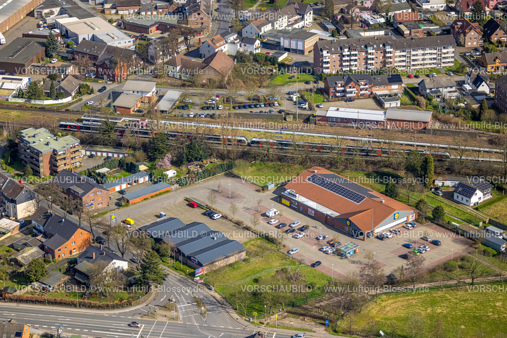 Voerde240309717 | Luftbild, Bahnhof Friedrichsfeld mit neuem Bahnsteig und S-Bahn, Ausbau der Betuweroute und Betuwe-Linie Eisenbahnstrecke, Einkaufszentrum mit Lidl Supermarkt und Getränke Hoffmann, Friedrichsfeld, Voerde, Nordrhein-Westfalen, Deutschland