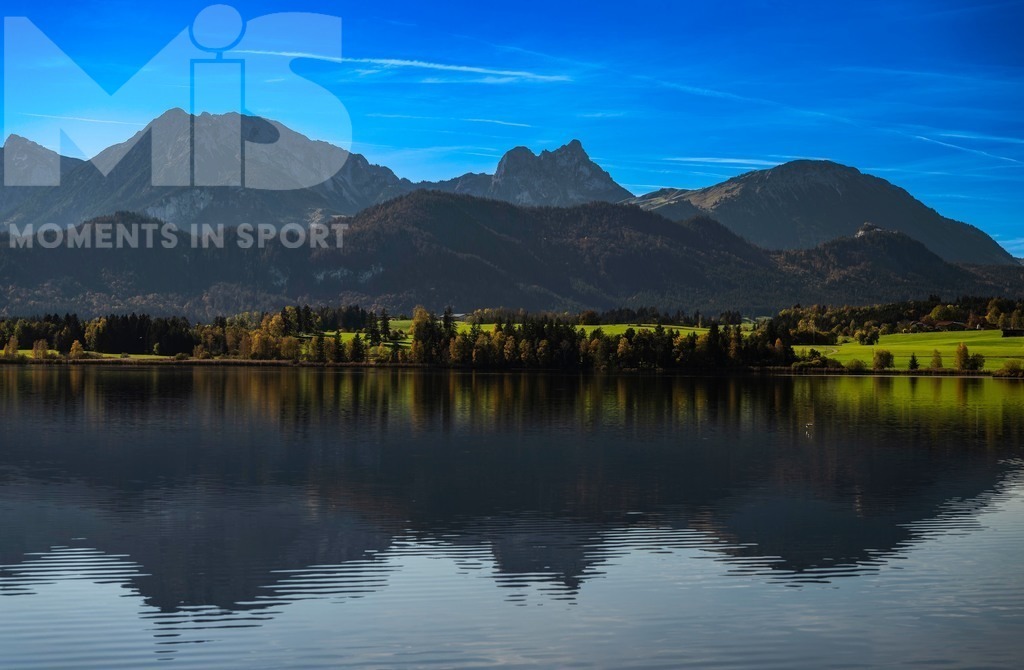 2.Liga-1860-HEIM.jpg | 17.10.2022, Herbst am Hopfensee im Allgäu (Bayern) bei Füssen. Die Bäume tragen Herbstlaub. Hinten mitte der Berggipfel Aggenstein. - Realisiert mit Pictrs.com