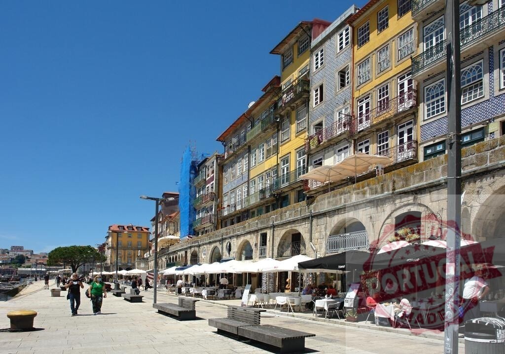 Ribeira district waterfront street with colorful buildings in Porto, Portugal | People walking and dining at outdoor cafes along the historic Ribeira district waterfront - Realisiert mit Pictrs.com
