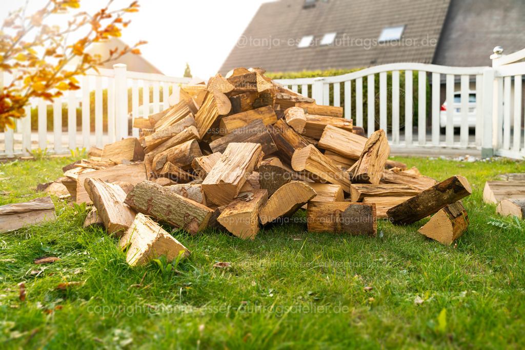 Brennholz Lieferung | Ein Stapel trockene Buchenholz Scheite wurde in den Vorgarten geliefert. Es ist Herbst und es wurde ein Vorrat an Brennholz zum Heizen im Winter besorgt.