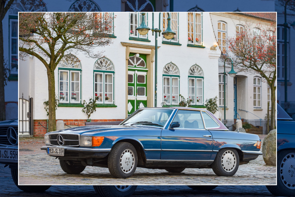 Mercedes 280 SL | Ein Mercedes 280 SL der Baureihe 107 in dunkelblau, das Hardtop in dunklem Magenta. Im Hintergrund sind Häuser am Südermarkt in Meldorf zu sehen. — Der Rahmen gibt einen abgedunkelten Ausschnitt des Bildes wieder. Auflösung des Originals: 6900 x 4600 px. - Realizzato con Pictrs.com