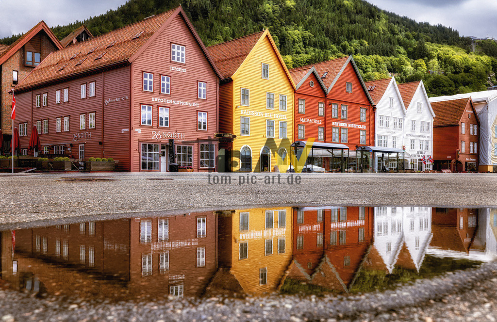 Typische hübsche Häuserzeile in Bergen - Bryygen--Norwegen | Das Bild zeigt das historische Hanseviertel Bryggen in Bergen, Norwegen. Bryggen (norwegisch für „Kai“) ist eine Reihe hanseatischer Geschäftsgebäude am Ostufer des Vågen-Hafens. Es ist die letzte erhaltene ehemalige Handelsniederlassung der Hanse und wurde 1979 von der UNESCO zum Weltkulturerbe erklärt. Die Gebäude wurden nach vielen Großbränden, zuletzt 1955, anhand alter Pläne teilweise wiederaufgebaut und zeugen von der einzigartigen hanseatischen Baukunst. Heute beherbergen die Häuser Geschäfte, Restaurants, Büros und Kunsthandwerksbetriebe und sind ein lebendiges Viertel.  - Realisiert mit Pictrs.com