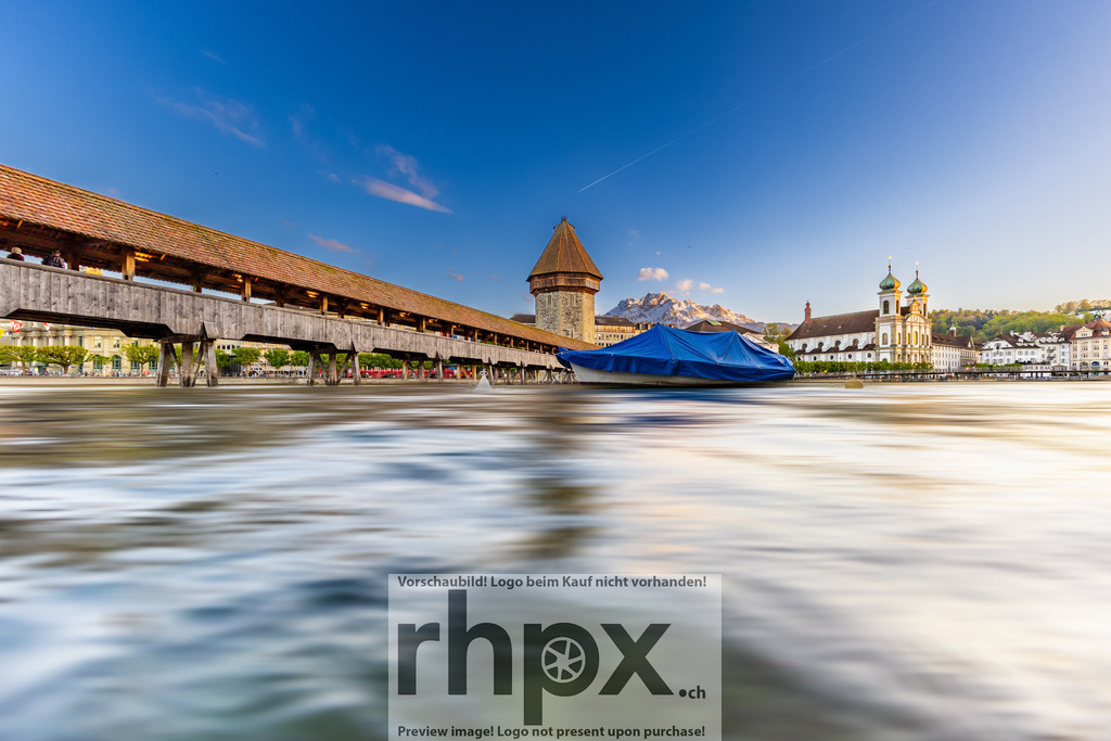 Kapellbrücke und Wasserturm Luzern in Langzeitbelichtung | Fluss. Zeit. Wahrzeichen.Durch die Technik der Langzeitbelichtung verwandelt sich die Reuss in einen seidenweichen Strom, der die historischen Ikonen der Stadt sanft umspielt. Ein kunstvolles Zusammenspiel aus der Beständigkeit von Stein und Holz und der fliessenden Bewegung des Wassers, das die zeitlose Schönheit Luzerns einfängt.Wähle unter "Produktauswahl" dein Wunschformat: Vom klassischen Wandbild über Puzzle &amp; Tassen bis zum digitalen Download (z.B. als Handy-Hintergrund). - Realisiert mit Pictrs.com