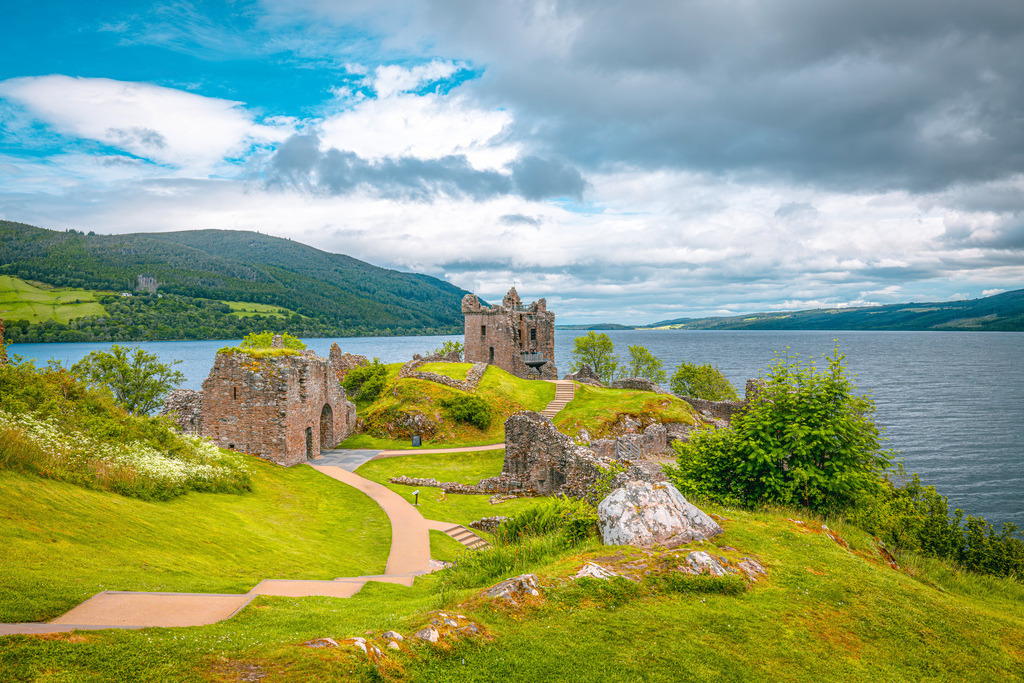 Die malerische Ruine des Urquhart Castle am Ufer des berühmten Loch Ness,Schottische Highlands | Das Bild zeigt die malerische Ruine des Urquhart Castle am Ufer des berühmten Loch Ness in den schottischen Highlands.Am Ufer des Loch Ness, nahe dem Ort Drumnadrochit in Schottland.Die Festung stammt in ihren Ursprüngen aus dem 13. Jahrhundert und spielte eine wichtige Rolle in den schottischen Unabhängigkeitskriegen.Die Anlage ist eine der meistbesuchten historischen Sehenswürdigkeiten Schottlands und bietet einen hervorragenden Blick über den See - Realisiert mit Pictrs.com