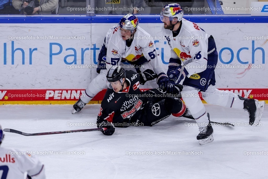 KEC28012501061 | 28.01.2025, Eishockey, DEL, Kölner Haie - EHC Red Bull München, Spieltag 41, Lanxess-Arena Köln: Emil Johansson (EHC München #57) und Konrad Abeltshauser (EHC München #16) im Zweikampf gegen Louis-Marc Aubry (Kölner Haie #15)