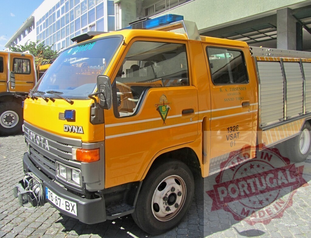 Toyota Dyna yellow fire truck parked on cobblestone street | Yellow Toyota Dyna fire truck from B.V. Tirsenses parked on a cobblestone street - Realized with Pictrs.com