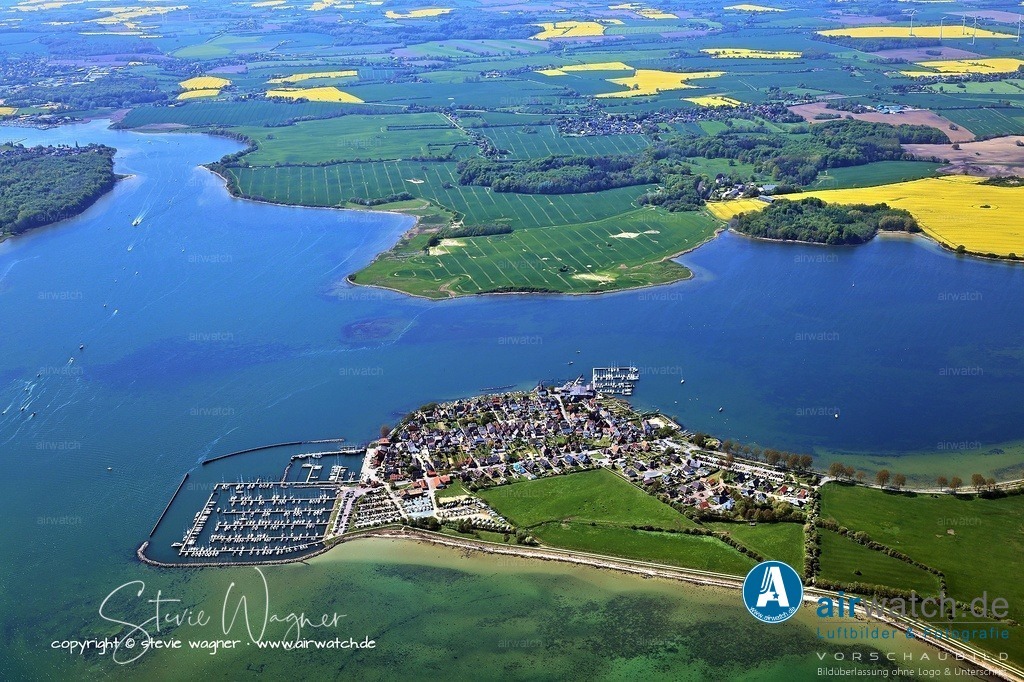 Luftbilder Ostseefjord Schlei, Maasholm, Port Olpenitz, Schleimünde | Maasholm ist bekannt für seine Hafenparty Mitte August mit Feuerwerk und Wasserspielen. Der traditionelle Saisonauftakt „Ansegeln“ findet am 17. Mai 2025 statt. Der Hafen trägt die Blaue Flagge für Umweltengagement. Alternativ zum Liegeplatz kann im Wormshöfter Noor geankert werden – ein landschaftlich reizvoller Ankerplatz mit Sand-Schlick-Grund.