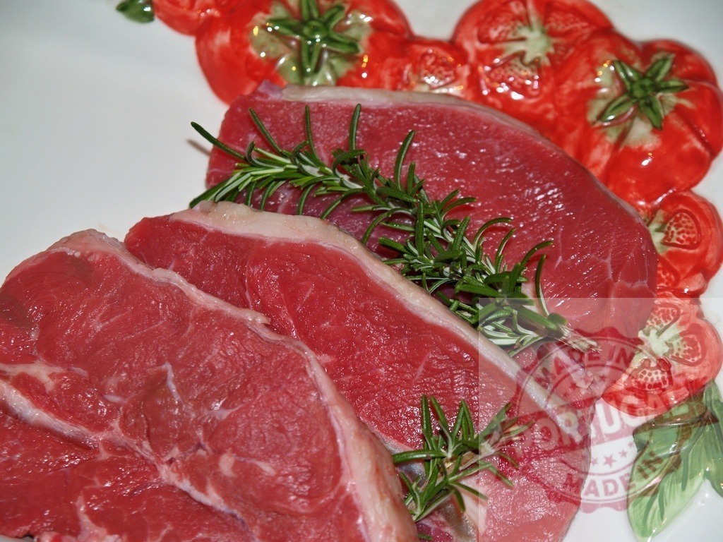 Fresh raw beef steaks with rosemary preparing for cooking | Raw beef steaks with fresh rosemary sprigs on a decorative plate, ready for culinary preparation - Realisiert mit Pictrs.com
