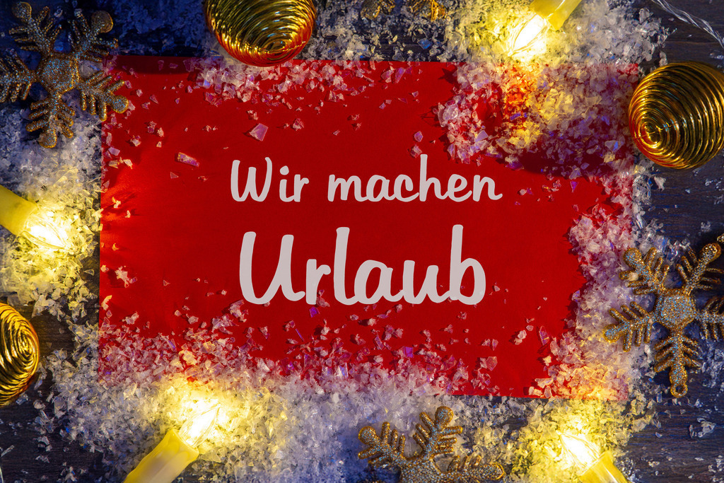 WIR MACHEN URLAUB  | Schild mit Aufschrift WIR MACHEN URLAUB mit weihnachtlicher Dekoration - Realisiert mit Pictrs.com