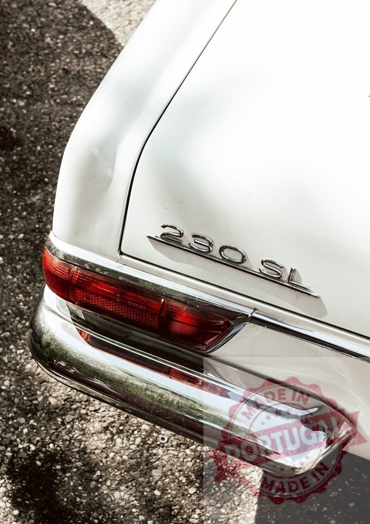 Close-up of a white Mercedes-Benz 230 SL rear light and bumper | Classic white Mercedes-Benz 230 SL parked on a gravel road, showing tail light and bumper - Realized with Pictrs.com