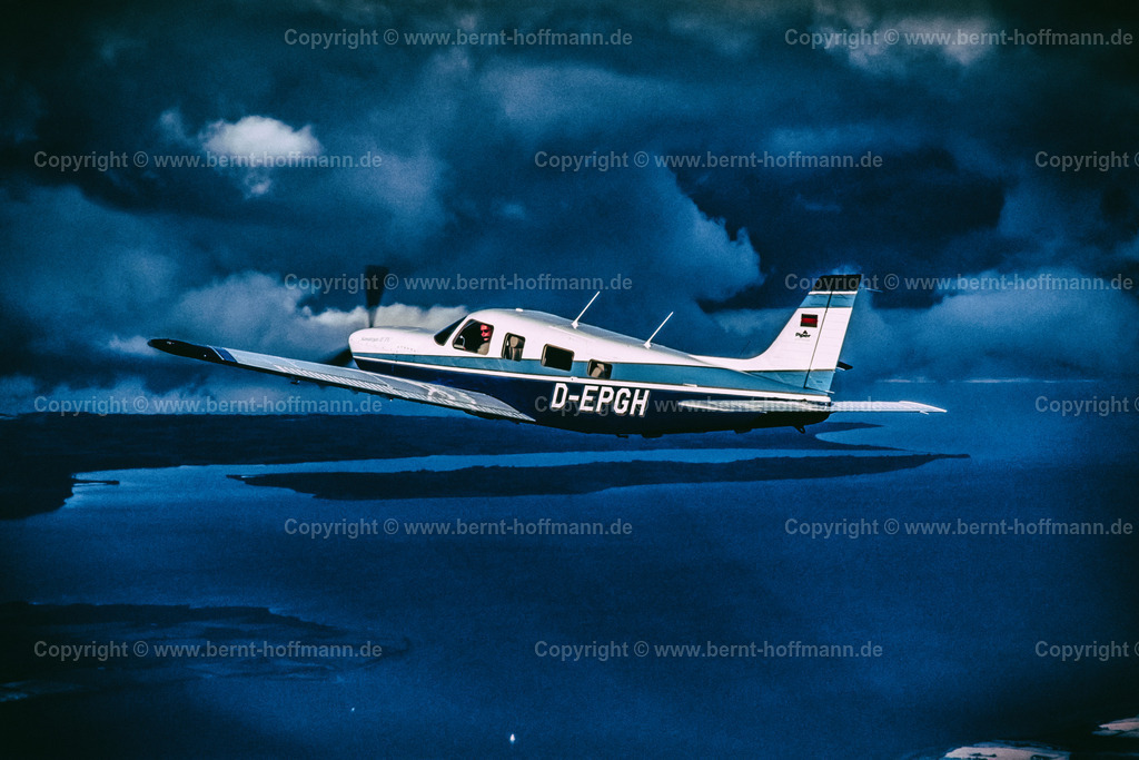 PLBDD_air2air_PiperSara_06b_90x60 | Luftbild. Einmotoriges Geschäftsflugzeug Typ " PIPER Saratoga II TC " unterhalb einer Wolkenschicht. Sonnenstrahlen erhellen die Szenerie. Flug über der Flensburger Außenförde. ___ Das Foto ist eine Reproduktion von einem Farbdia. Bildanmutung - farbreduziert. - Realisiert mit Pictrs.com