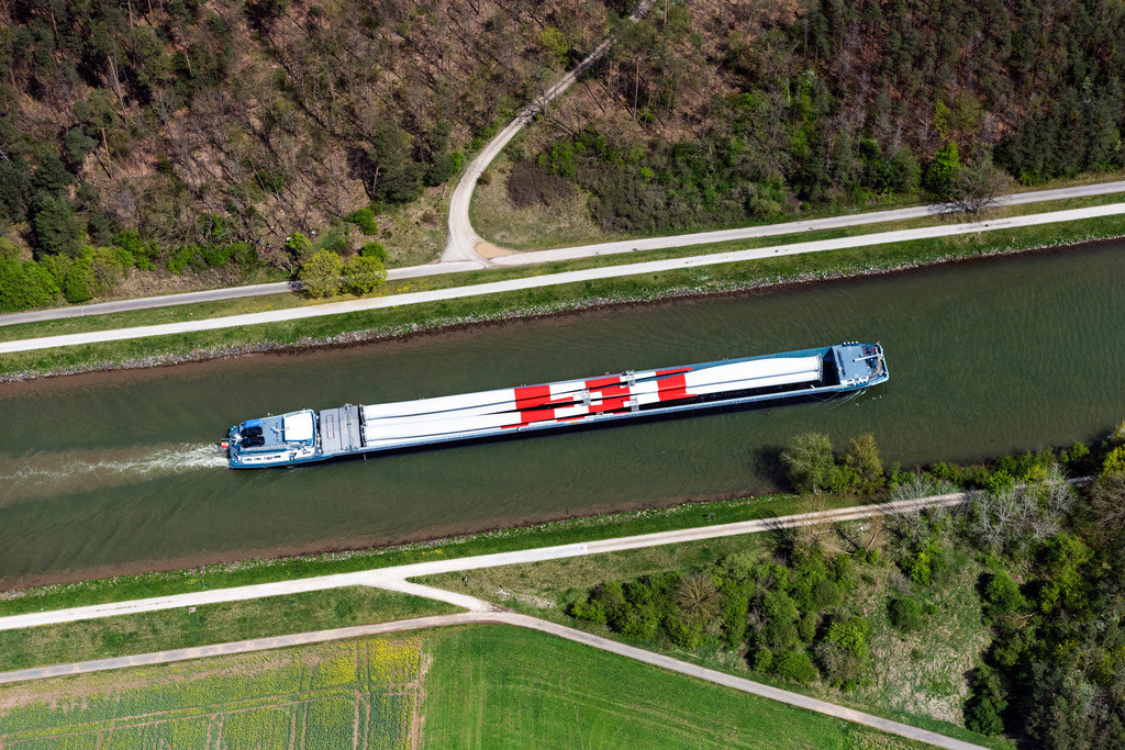 dr__0095753.jpg | BAMBERG 28.04.2022 Schiffe und Schleppverbände der Binnenschiffahrt in Fahrt auf der Wasserstraße des Flußverlaufes der Regnitz beladen mit großen Windrad Blättern in Bamberg im Bundesland Bayern, Deutschland. // Ships and barge trains inland waterway transport in driving on the waterway of the river of Regnitz beladen with grossen Windrad Blaettern in Bamberg in the state Bavaria, Germany. Foto: Daniel Reiter