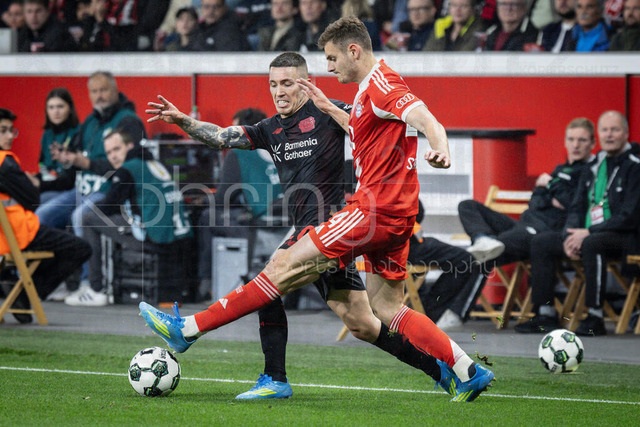 DFB Cup semifinal match Bayer 04 Leverkusen vs. FC Bayern Munich, 22.04.2026 | LEVERKUSEN, GERMANY - APRIL 22, 2026: Alejandro Grimaldo (Bayer 04 Leverkusen, 20), Josip Stanisic (FC Bayern Muenchen, 44) tackling during the German DFB Cup semifinal match between Bayer 04 Leverkusen vs. FC Bayern Munich at BayArena on April 22, 2026 in Leverkusen, Germany. DFL REGULATIONS PROHIBIT ANY USE OF PHOTOGRAPHS AS IMAGE SEQUENCES AND/OR QUASI-VIDEO.