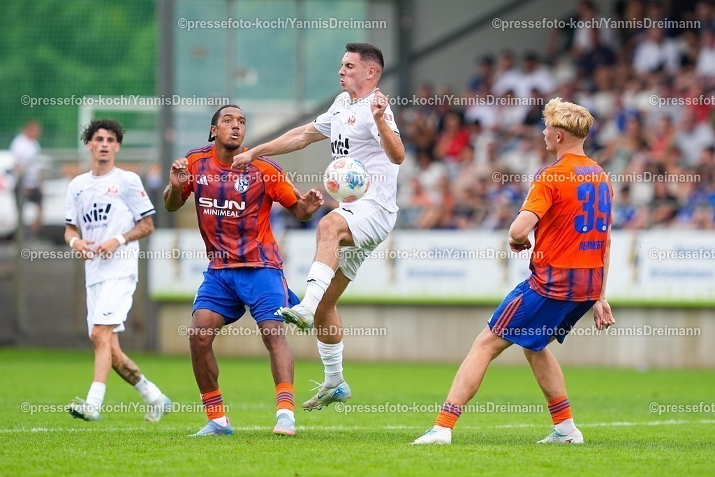 xYDR20072501112 | 20.07.2025, xydrx, Fußball, Rot Weiss Ahlen - FC Schalke 04, Testspiel, Wersestadion: Anton Donkor (FC Schalke 04 #30)im Zweikampf gegen Emro Curic (Rot Weiss Ahlen #7)  und Peter Remmert (FC Schalke 04 #39)