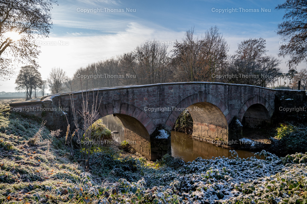 DSC_5072 | Im Winter entfaltet die Wattenheimer Brücke bei Lorsch eine besondere Atmosphäre. Das historische Bauwerk, das den Wattenheimer Bach überspannt, ist nicht nur ein Zeugnis alter Ingenieurskunst, sondern auch ein stiller Ort von landschaftlicher Schönheit. Eingebettet in die winterliche Umgebung nahe des UNESCO-Welterbes Kloster Lorsch, wirkt die Brücke unter Schnee und Raureif wie ein malerisches Relikt vergangener Zeiten.

Die Brücke erinnert an die lange Geschichte der Region: Als Teil alter Verbindungswege diente sie über Jahrhunderte hinweg Handel, Landwirtschaft und Pilgern. Heute ist sie ein beliebtes Fotomotiv und Ausflugsziel für Spaziergänge rund um Lorsch und das Ried.