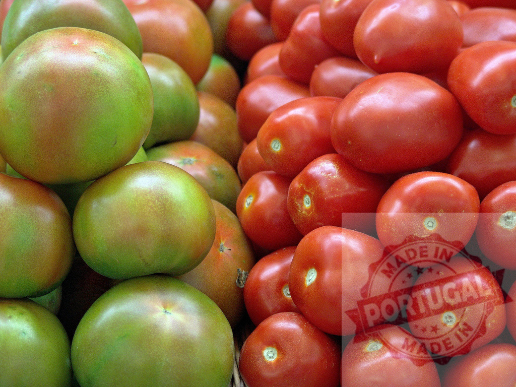 Ripening tomatoes displaying contrast between green and red | Green and red heirloom tomatoes showing stages of ripeness, ready for harvest at a market - Realized with Pictrs.com
