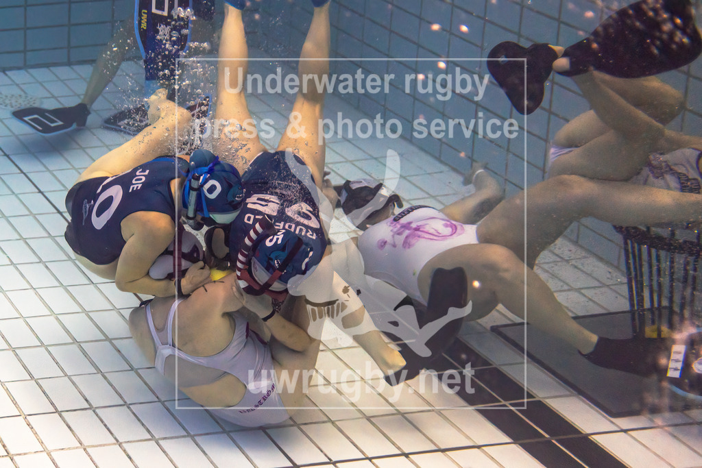 24. - 26.11.2023: Unterwasser-Rugby Champions Cup 2023  | Damen-Spiel: Amager Uv-Rugby (Dänemark) in blau gegen Black Mermaids (Schweden) in weiß. Johanne Press Wegeberg (blau #10) und Mille Grønborg Rudfeld (blau #95) versuchen von der schwedischen Spielerin Emma Lindström (weiß #7) den Ball zu erkämpfen. - Realisiert mit Pictrs.com