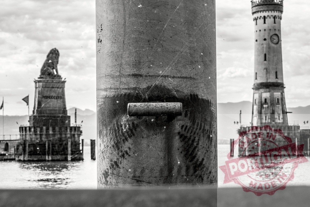 Mooring bollard showing Lake Constance with the Bavarian Lion and the New Lighthouse in Lindau, Germany | Black and white photography of a mooring bollard showing Lake Constance with the Bavarian Lion and the New Lighthouse in Lindau, Germany - Realisiert mit Pictrs.com
