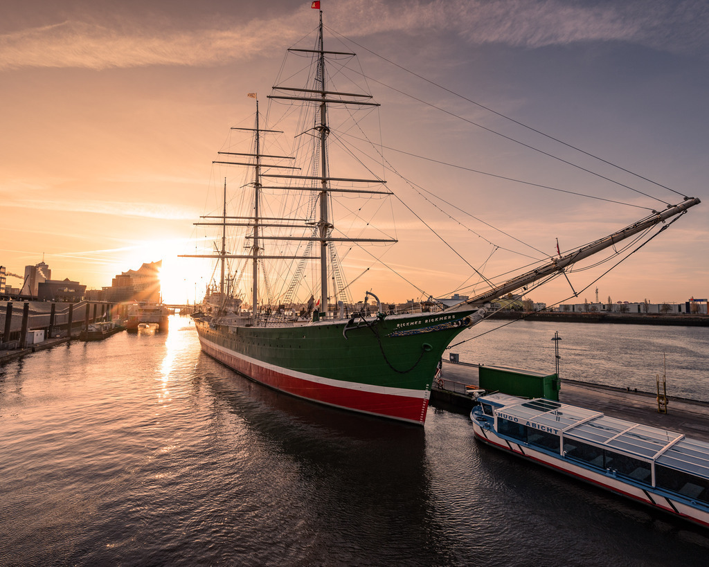 Rickmer Rickmers im Morgenlicht – Hamburger Hafen | Ein historisches Segelschiff im warmen Gegenlicht des Hamburger Hafens – maritimer Charakter zwischen Elbe, Hafenbecken und aufgehender Sonne. - Realisiert mit Pictrs.com