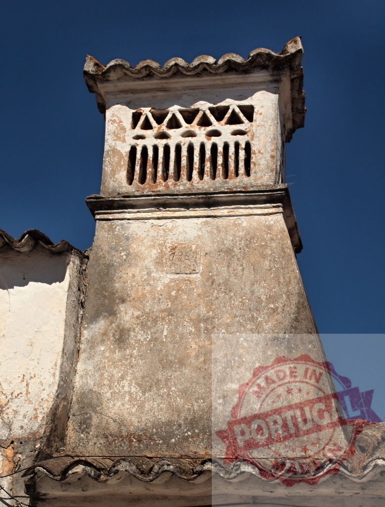Traditional weathered stone chimney against blue sky | Old chimney featuring decorative vents and an aged texture on a building roof - Realisiert mit Pictrs.com