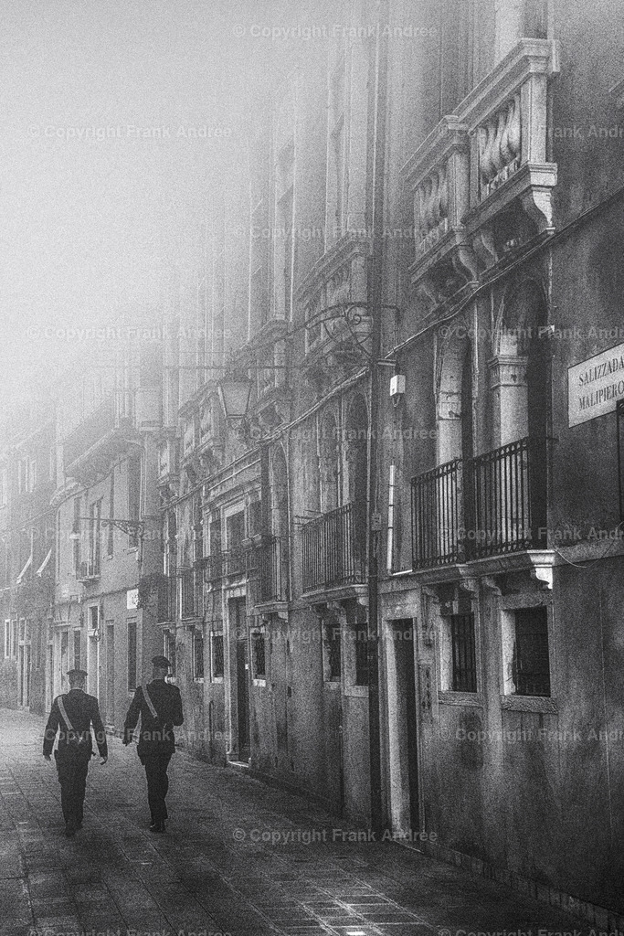 Carabinieri Venedig | Zwei Carabinieri gehen durch eine Gasse in der Altstadt von Venedig. Straßenfotografie aus Italien in schwarz und weiß - Realisiert mit Pictrs.com