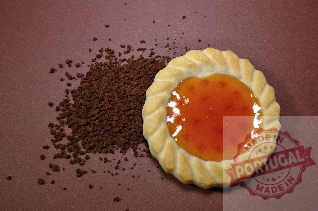Cookie with apricot jam and instant coffee granules | Cookie with apricot jam filling next to scattered instant coffee granules on a brown background - Realisiert mit Pictrs.com