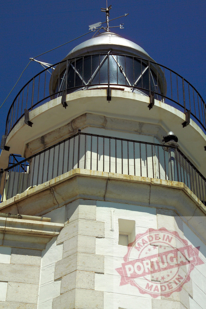 Lighthouse lamp house and weathervane under blue sky | Lighthouse illuminating maritime safety and navigation against a clear blue sky - Realized with Pictrs.com