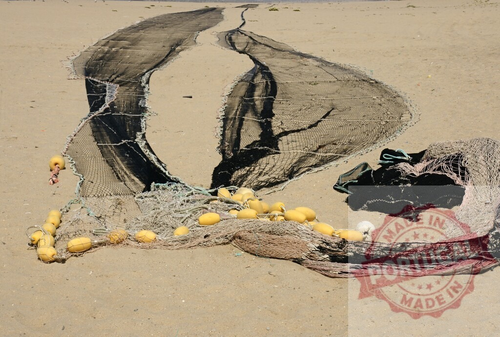 Aveiro Region - Portugal Fishing net spread on sandy beach with floats | Fishing net with floats drying on a sandy beach under sunlight - Realisiert mit Pictrs.com