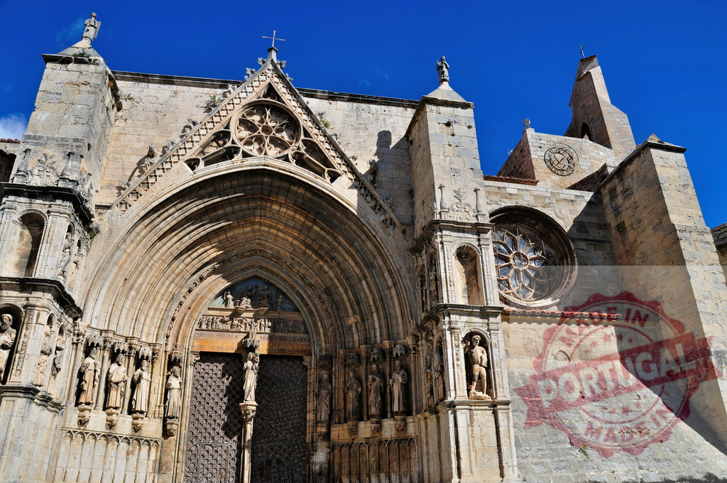Tarragona Cathedral depicting gothic architecture and stone statues. Spain - Castellon | Tarragona Cathedral displaying religious art, historic facade, and main portal under blue sky - Realized with Pictrs.com