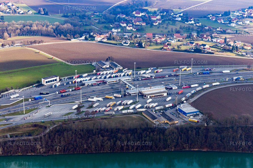 Aerial view: Motorway border crossing, truck border controls on the A8 from Austria to the A3 in Germany at the Inn River in Suben in the state Upper Austria, Austria. – Photo: IMG_096070.jpg taken on 12/29/2016 by Werner Riehm/FLY-FOTO.com – Resolution of the original: 4827 x 3218 px