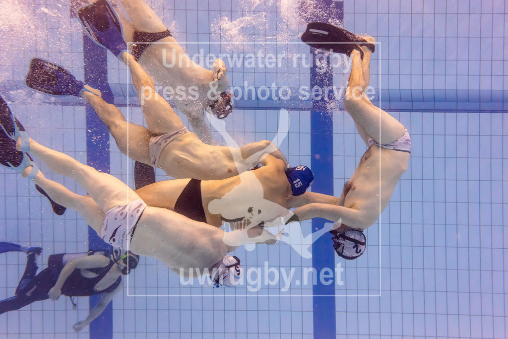 Unterwasser-Rugby 5. Spieltag 1. Bundesliga Süd (Saison 2023/24) | Das Spitzenspiel der 1. Bundesliga Süd zwischen dem TSV Malsch (weiß) und dem Tauchclub Bamberg (blau) setzte den Höhepunkt des Spieltages. Das Duell entschied über den 1. Platz in der Liga und den Titel des Süddeutschen Meisters. Nachdem Bamberg in der Hinrunde gegen Malsch gewonnen hatte, triumphierte dieses Mal Malsch mit einem knappen 1:0-Sieg. Andreas Weißenberger mit der Nummer 15 wird von zahlreichen Malschern Spielern im Mittelfeld des Spielfeldes angegriffen. - Realisiert mit Pictrs.com