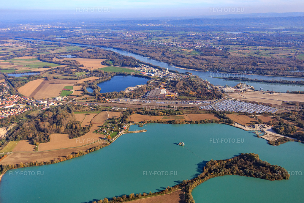 Vue aérienne: ARCHICUB - Aire de stationnement pour l'importation des camions et des voitures du Walon, de l'autre côté du lac de baignade à Lauterbourg dans le département Bas Rhin, France.Photo: IMG_075819.jpg prise le 02/11/2014 par Werner Riehm/FLY-FOTO.euRésolution de l'original: 5175 x 3450 pxSolutions logistiques pour l'industrie: