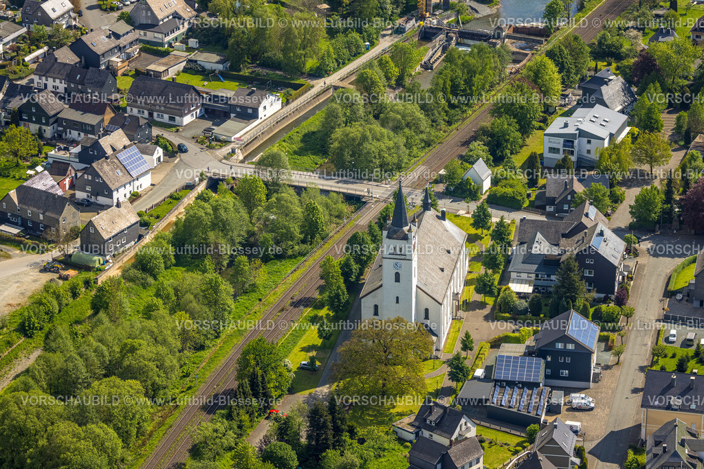 Bestwig240502873 | Luftbild, katholische Kirche St. Andreas, Wohngebiet Mühlenstraße Ecke Kanalstraße, Bahnlinie Bahnübergang und Ruhrbrücke Kanalstraße, Fluss Luchtmücke und begrünter Fluss Ruhr, Wohngebiet, hinten das Stauwehr Velmede, Velmede, Bestwig, Sauerland, Nordrhein-Westfalen, Deutschland