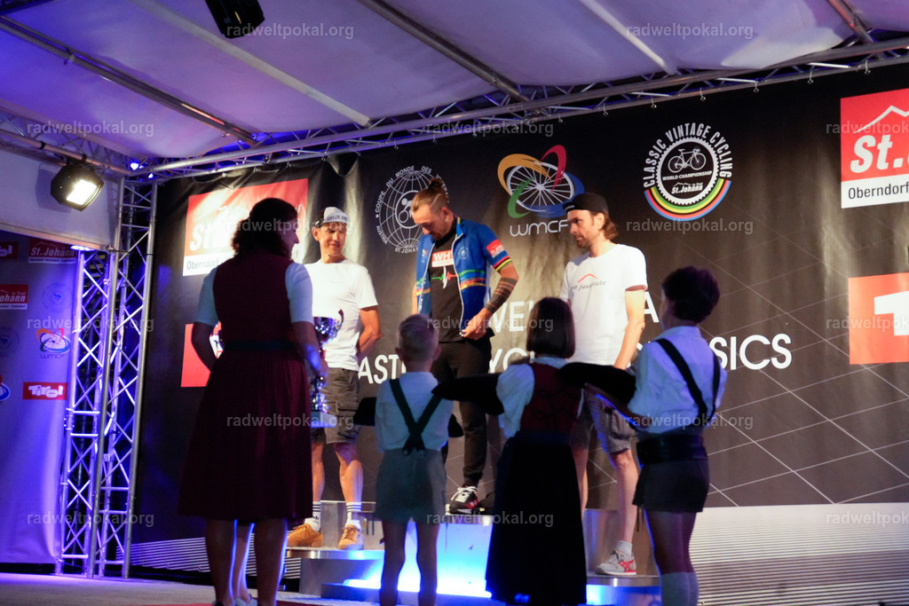 1363_20230817_Bewerb_Maenner_Muehlanger | AUT - OESTERREICH, 2023-08-16: SPORT RENNRAD-FAHREN - 55. INTERNATIONALER RADWELTPOKAL IN ST. JOHANN IN TIROL  - Vintage-Radrennen mit WM-Bronze-Medaillen-Siegerin Christina Schweinberger, den Teilnehmer und Alexander Baumann (vom Orginastions-Team) - TAG 2 BEWERB MAENNER IN SECHS GRUPPEN  ; Foto: Roland Muehlanger